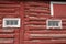 White framed hay loft door and windows on an old red barn