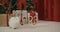 White, furry rabbits sitting, playing on floor in cozy studio decorated with christmas tree.