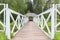 White gazebo in the Park on the island, around the green island on a summer day in the tall lush grass among