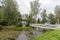 White gazebo in the Park on the island, around the green island on a summer day in the tall lush grass among