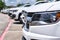 White generic fleet SUV`s parked in a lot, side closeup on front of vehicle with focus on foreground.