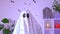 White ghost costume for Halloween party with neon lights in the background. Ghost at confetti party.