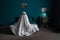 White ghost sitting on bed in bedroom, halloween concept.