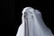 White ghost in white cloth on isolated black background. Face devil shouting covered curtain on blank. Halloween concept