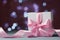 White gift box or present against magic bokeh background. Greeting card for Christmas, New Year or wedding.