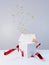 White gift box with red bow opens with an explosion of confetti and a blank card appears