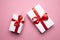 White Gift Boxes With Red Ribbons On Pink Background, Top View. Valentines Day Holiday Anniversary Birthday Idea