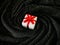 White gift boxes tied with red bow on center of black spiral background.
