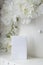 White gift wrap on a background of decorative artificial flowers