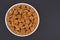 White glass bowl of crispy rye crouton bread biscuits. Isolated on a dark grey background.