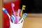 White glass with lots multicolored toothbrushes. Dental care and oral hygiene. Tongue cleaning. Big family concept