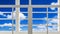 White glass window and sunshade battens with blurred white cloud in blue sky background, view from inside of building