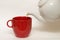 White glazed faience tea pot and red cup