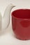 White glazed faience tea pot and red cup