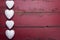 White glitter hearts on a red wooden background