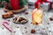 White glogg or mulled wine with apple slices and cinnamon stick, almond nuts with cranberry, candy cane and gift box on background