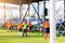 White goalposts and mesh of goal with blurry football players.