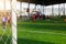 White goalposts and mesh of goal with blurry football players