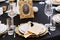 White and golden plates on black tablecloth. Beautiful service of wedding tables.