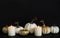 White, golden pumpkins and burning candles on black background. Halloween concept