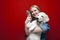 White golden retriever gives a paw to the hostess on a red background, a young beautiful girl holds a puppy and teaches teams