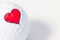 White golf ball with red heart.