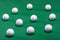 White golf balls scattered on a green carpet