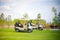 White golf car on the green golf field on beautiful sunny day