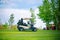 White golf car on the green golf field on beautiful sunny day