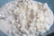 White granular cottage cheese in a blue plate,