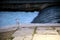 White, gray and black seagull resting on the urban edge of the river waterfall