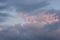White and gray clouds with pink sunset highlights. The glare of the sun on the clouds. Background