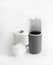 White and gray plastic toilet brush and roll of toilet paper on white background