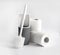 White and gray plastic toilet brush and roll of toilet paper on white background