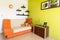 White and green bedroom with orange sofa