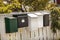 White and green mailboxes on a wooden white fence