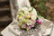 White green, pink and yellow and pink wedding bouquet with roses on the stone. Colorful image of beautiful nosegay