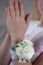 White and green wrist corsage on a hand. Holy commiunion