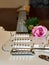 White guitar with a pink rose on the side of soundboard