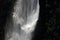 WHITE GUSHING WATERFALL AGAINST A DARK CLIFF