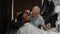White guy doing a haircut to a young joyful african american guy in a beautiful barbershop