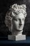 White gypsum copy of ancient statue of Apollo God of Sun head for artists on a dark textured background. Renaissance