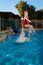 White Haired Grandfather Throws His Granddaughter in the Swimming Pool the Girl has a Big Smile on her Face as She Flies Through