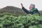 A white-haired senior man in excursion at the mountain under the rain. Active retiree backpacker enjoying the outdoors and freedom