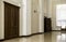 White hallway with marble floor, brown doors and window