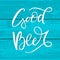 White hand drawn brush lettering Good Beer on cyan wooden plaque