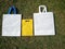 white handbags, yellow Eco friendly non woven fabric bags on grass