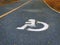 White Handicapped Symbol on Asphalt Road in the Park