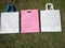 white handle loop bag with pink color d cut Eco friendly bags, non woven fabric bags on grass