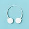 White headphones on blue sky colored paper background. Music concept. Dj Headset